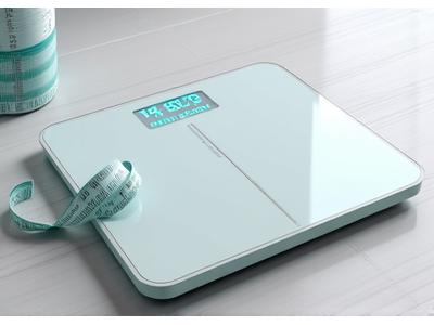 A sleek, digital smart scale displaying accurate body composition metrics, accompanied by a measuring tape and progress chart, for effective health tracking.