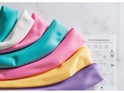 An aesthetically pleasing set of resistance bands of varying strengths, coiled neatly, alongside a brochure illustrating stretching exercises, indicating versatile fitness solutions.